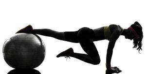 one woman exercising fitness workout plank position on fitness ball in silhouette on white background
